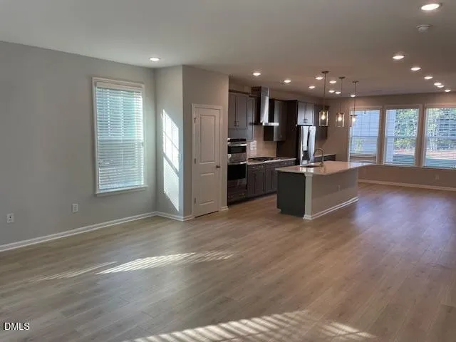 a view of kitchen with refrigerator stove and wooden floor
