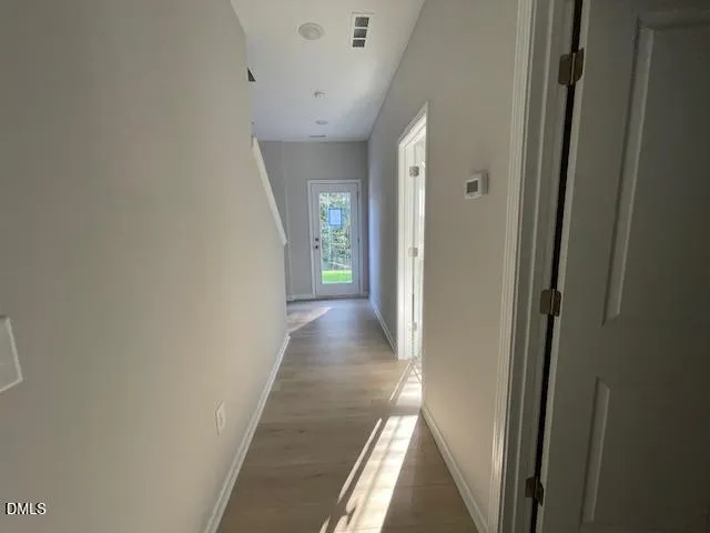 a view of a hallway with wooden floor