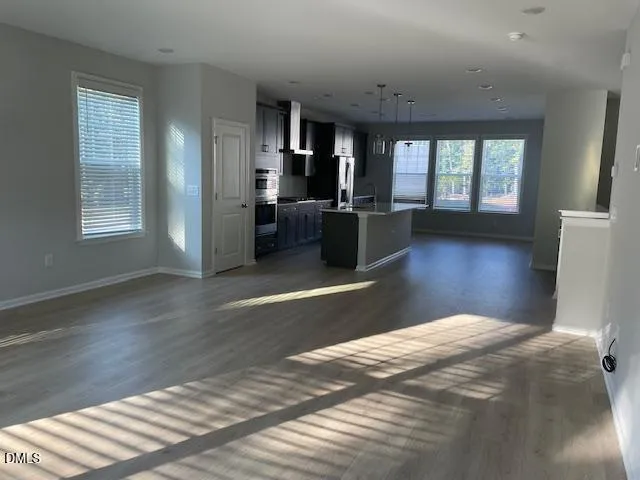 a bedroom with wooden floor and window