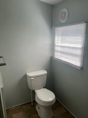 a white toilet sitting next to a window