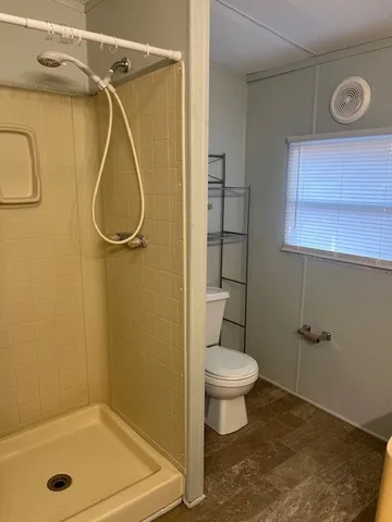 a bathroom with a shower a toilet and a shower