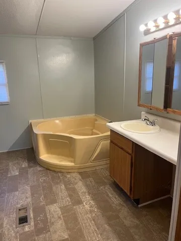 a bathroom with a sink a toilet a mirror and bathtub