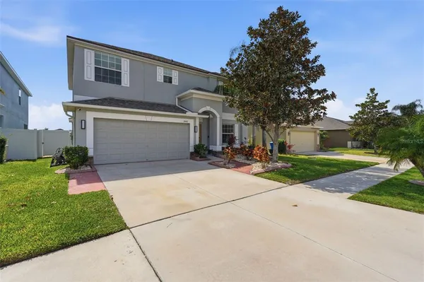 a front view of a house with a yard and a garage