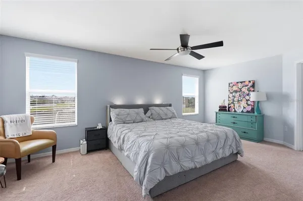 a spacious bedroom with a bed a table and chairs