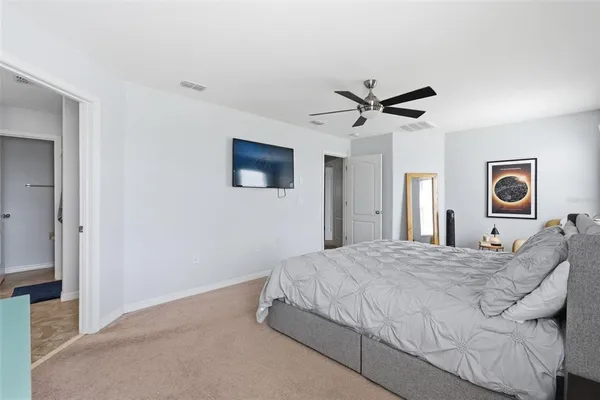a bedroom with a bed and a ceiling fan