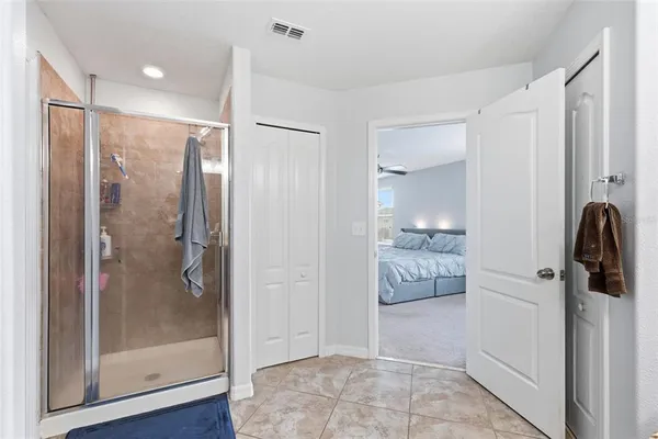 a spacious bedroom with a bed and a ceiling fan
