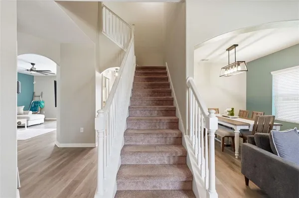 a view of a dining room and livingroom with furniture wooden floor and a chandelier