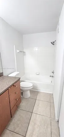 a bathroom with a granite countertop sink a toilet and a bathtub