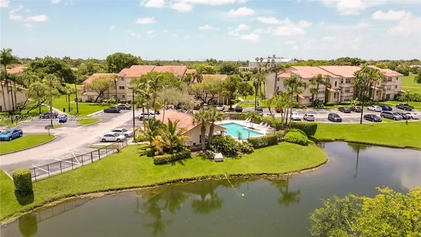 an aerial view of a house with a garden and lake view