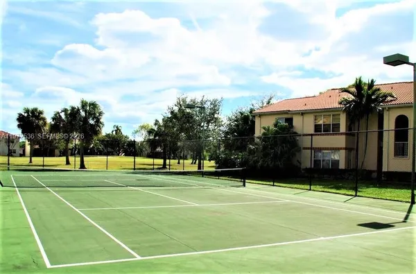 a view of a tennis ground with a big yard