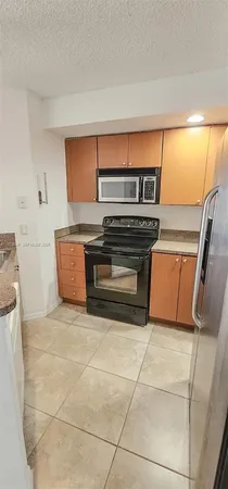 a kitchen with granite countertop a stove and a microwave