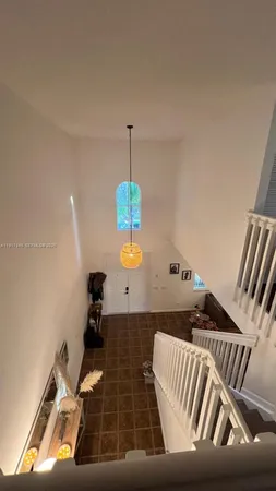 a view of a hallway with wooden floor and stairs