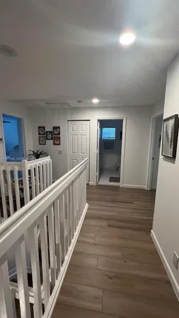 a view of a hallway with wooden floor and windows