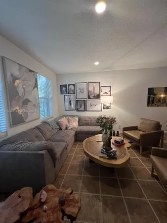 a living room with furniture and painting on the wall