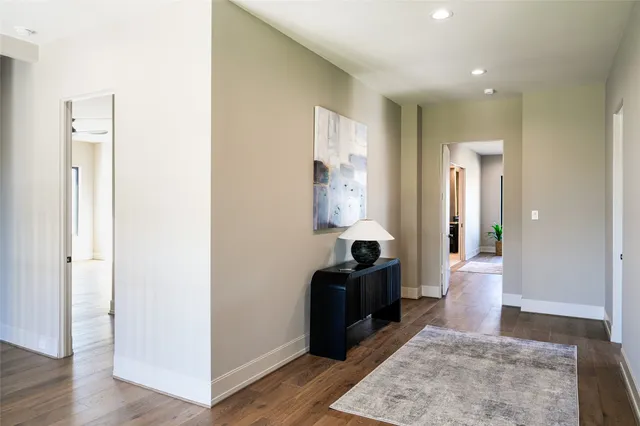 a view of a hallway with wooden floor and cabinet