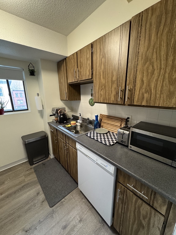 49 Marion Street, Unit 4D Brookline, MA 02446 - Photo 2 of 8 a kitchen with sink cabinets and stove top oven