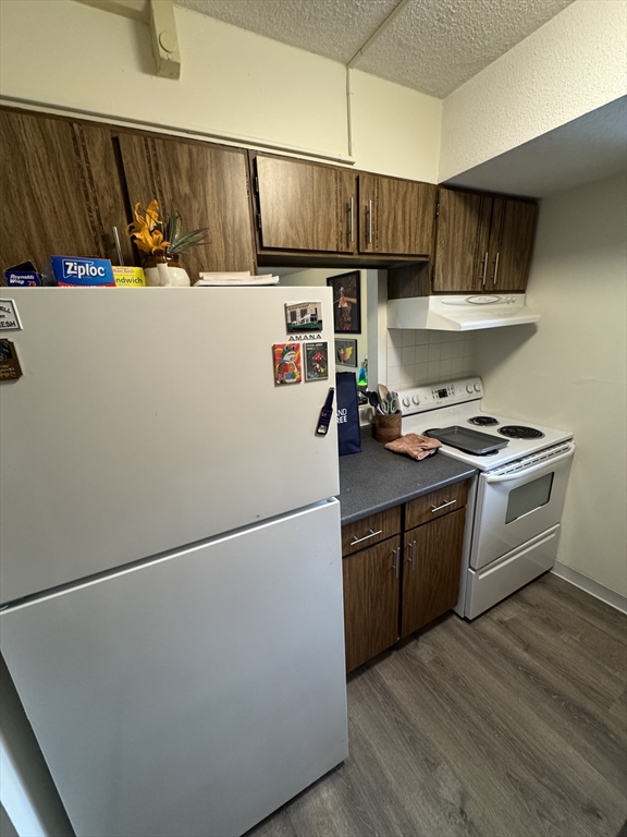 49 Marion Street, Unit 4D Brookline, MA 02446 - Photo 3 of 8 a kitchen with stainless steel appliances a refrigerator and a stove top oven