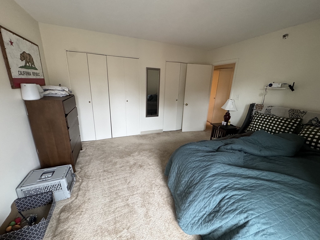 49 Marion Street, Unit 4D Brookline, MA 02446 - Photo 6 of 8 a bedroom with a bed and wooden floor
