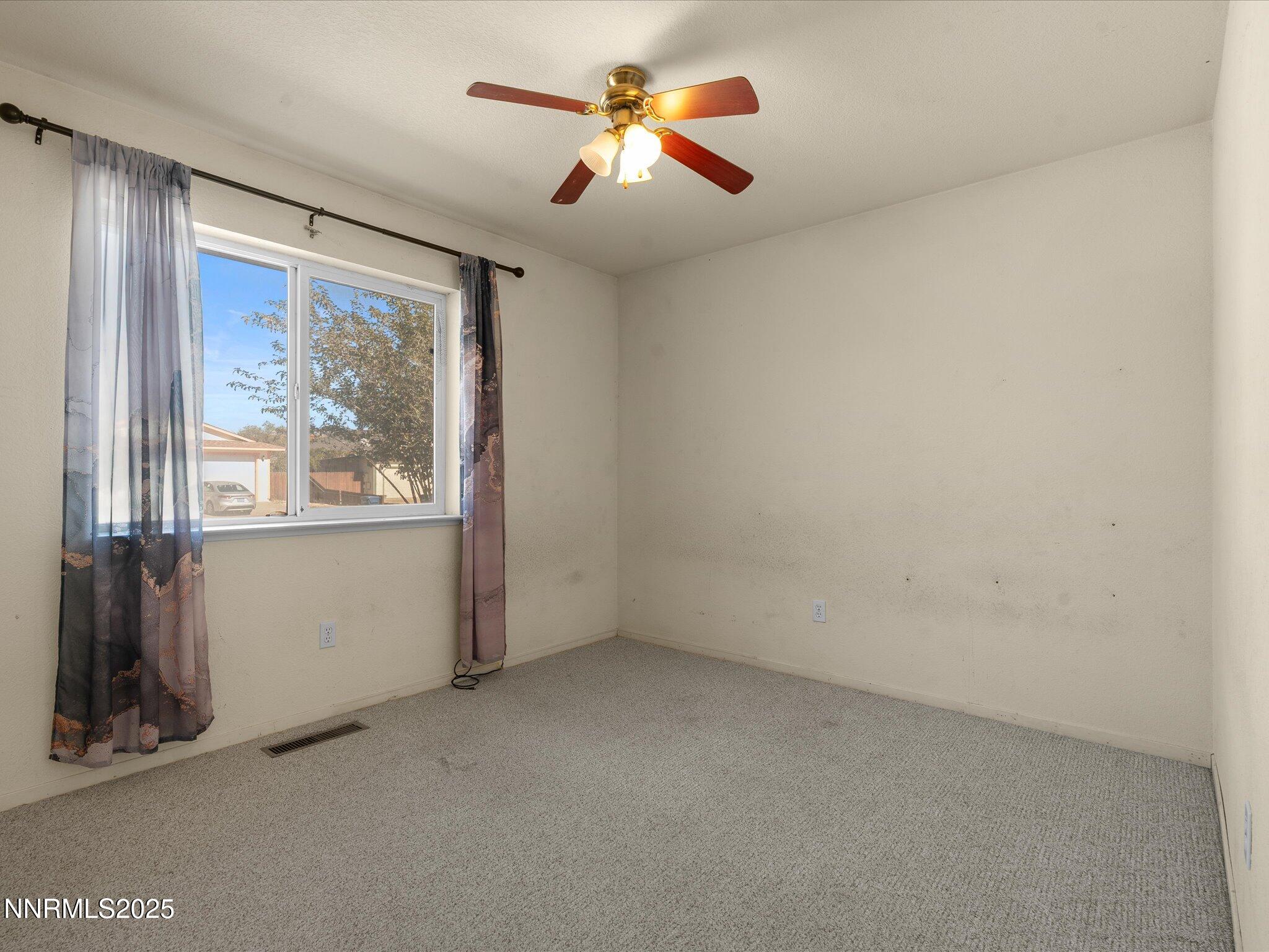 397 Nader Way Fernley, NV 89408 - Photo 17 of 27 an empty room with windows and fan