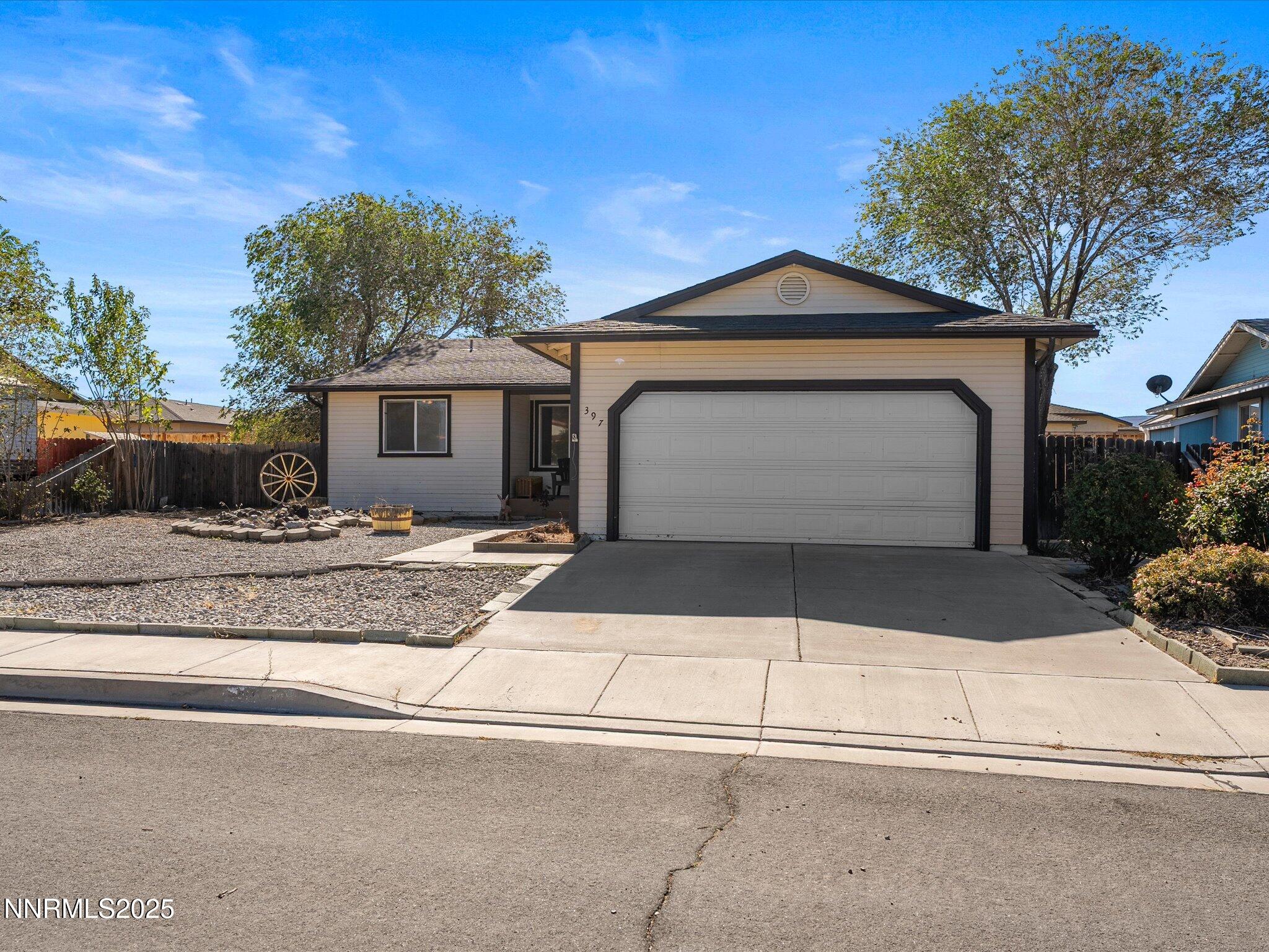 397 Nader Way Fernley, NV 89408 - Photo 3 of 27 a front view of a house with a yard and garage