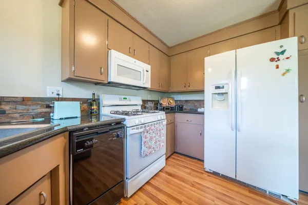 a kitchen with stainless steel appliances granite countertop a refrigerator sink and cabinets