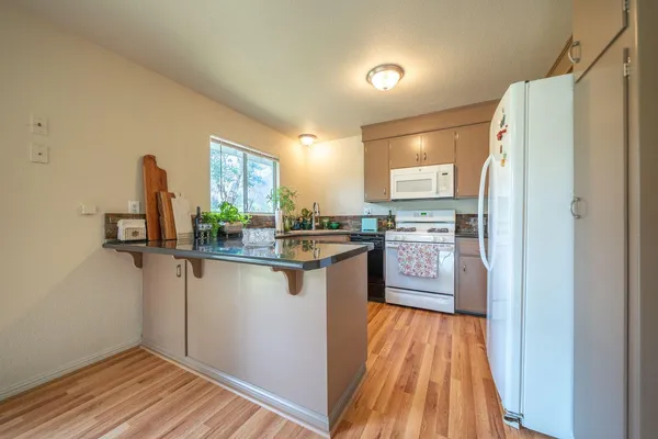 a kitchen with granite countertop a refrigerator and a sink