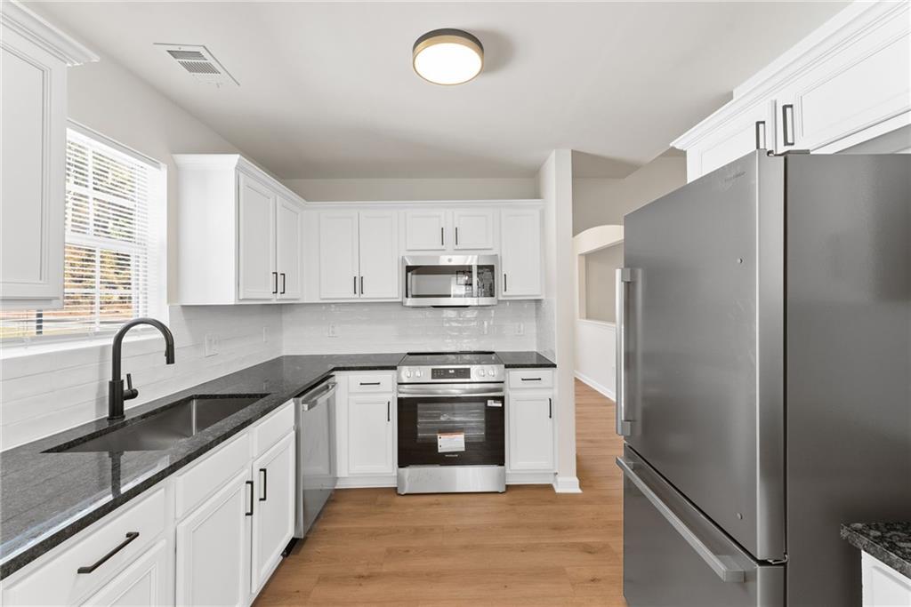 5805 Marbut Road Lithonia, GA 30058 - Photo 17 of 46 a kitchen with granite countertop a refrigerator stove and sink