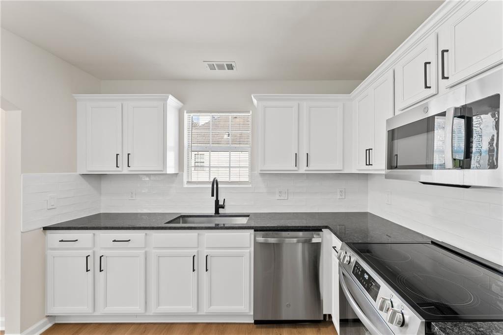 5805 Marbut Road Lithonia, GA 30058 - Photo 18 of 46 a kitchen with granite countertop white cabinets and a sink