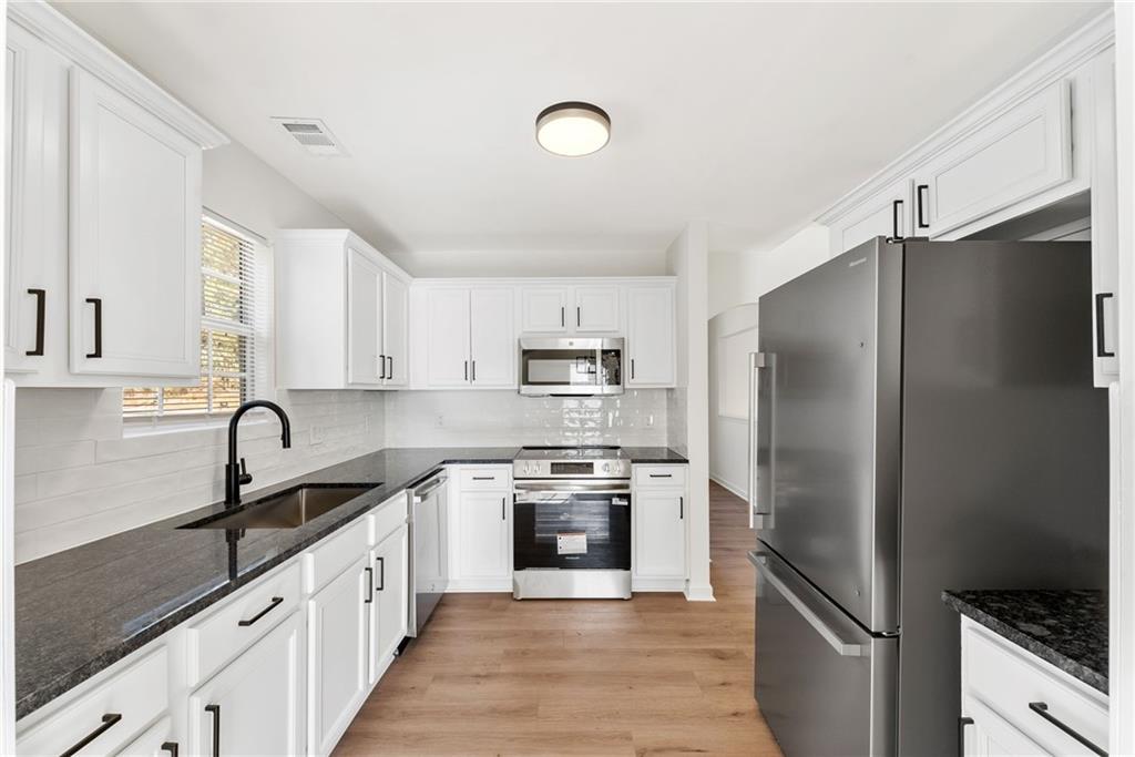 5805 Marbut Road Lithonia, GA 30058 - Photo 19 of 46 a kitchen with granite countertop a refrigerator and a sink