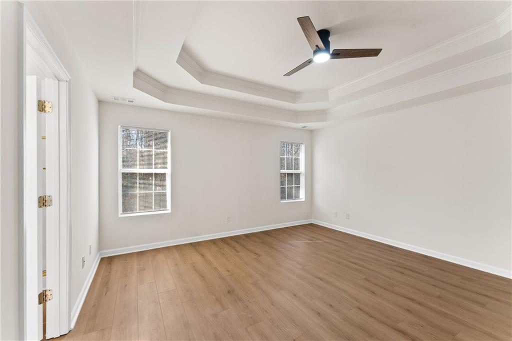 5805 Marbut Road Lithonia, GA 30058 - Photo 22 of 46 an empty room with wooden floor fan and windows