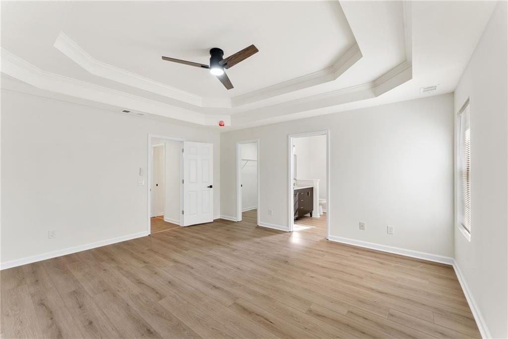 5805 Marbut Road Lithonia, GA 30058 - Photo 23 of 46 an empty room with wooden floor ceiling fan and windows