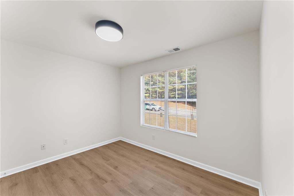 5805 Marbut Road Lithonia, GA 30058 - Photo 28 of 46 an empty room with wooden floor and windows