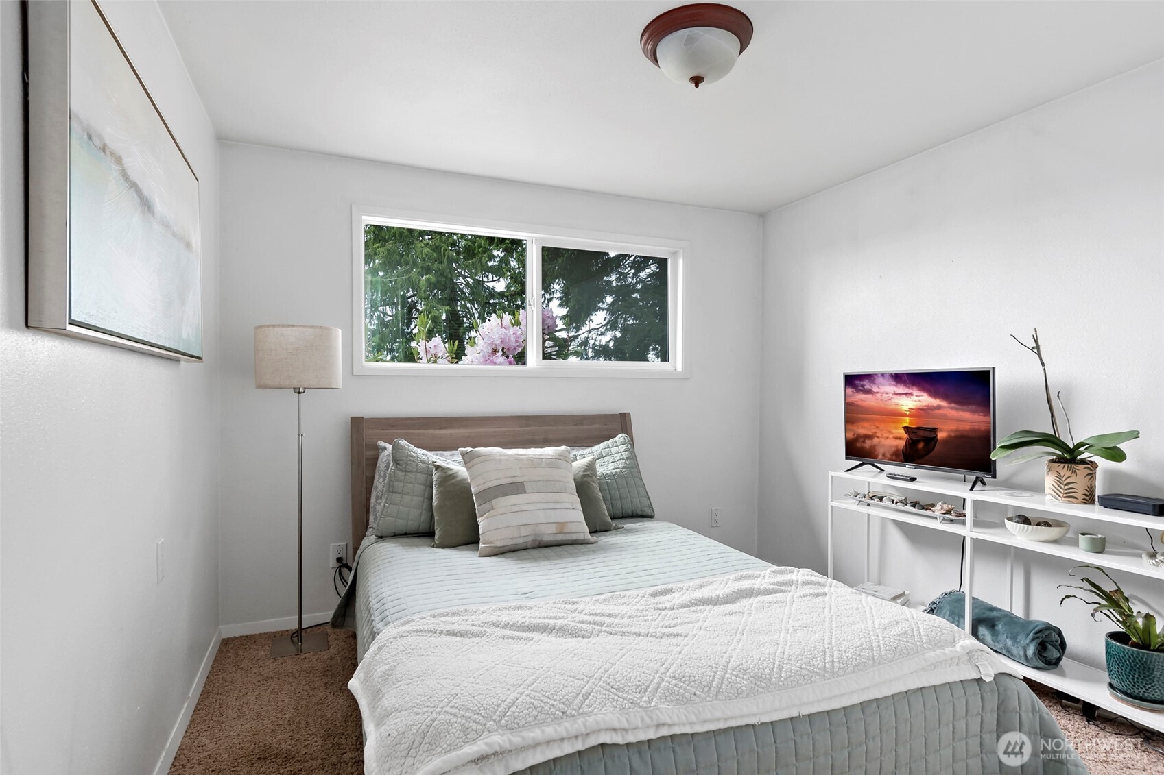 5222 East Harbor Road Freeland, WA 98249 - Photo 22 of 39 a bedroom with a bed and a flat tv screen on dresser