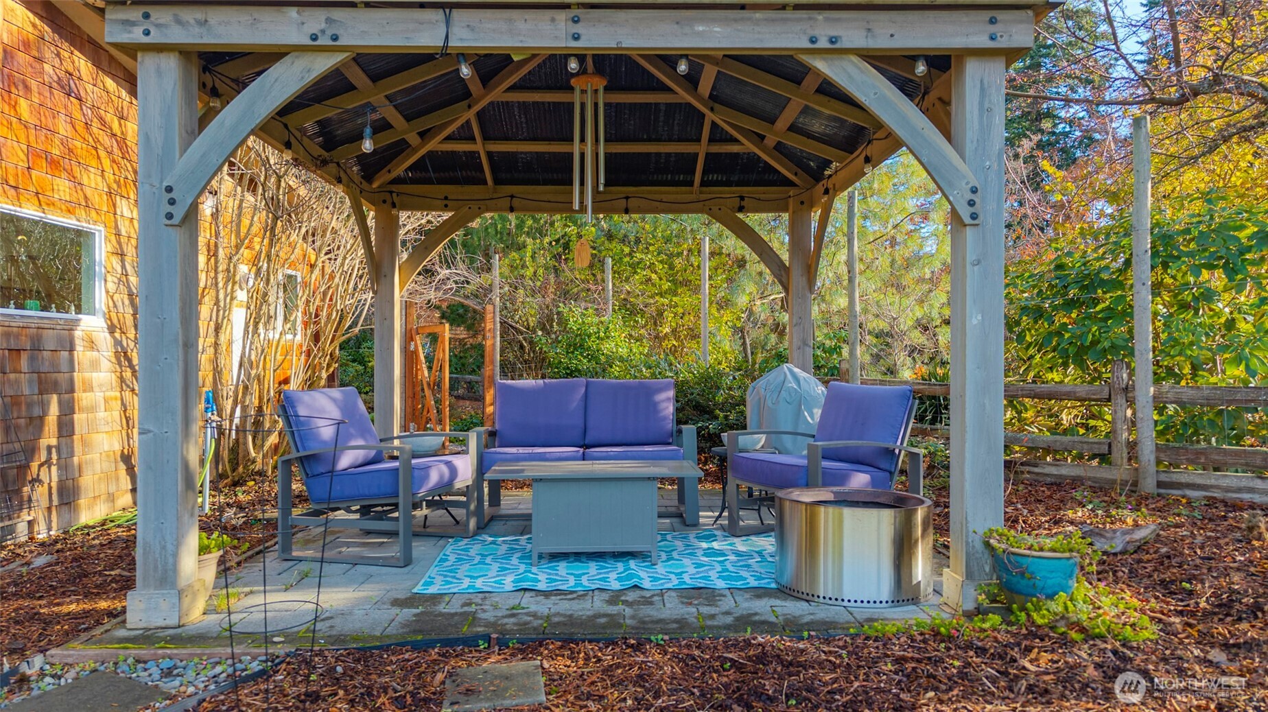 5222 East Harbor Road Freeland, WA 98249 - Photo 6 of 39 a view of a patio with table and chairs potted plants and floor to ceiling window