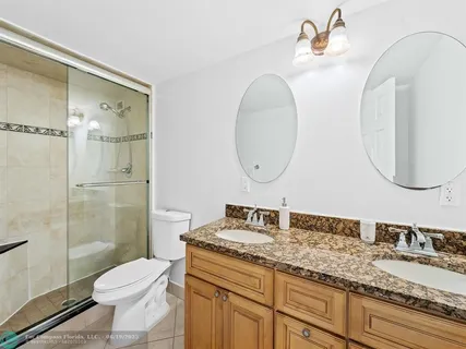 a bathroom with a granite countertop toilet sink and a mirror