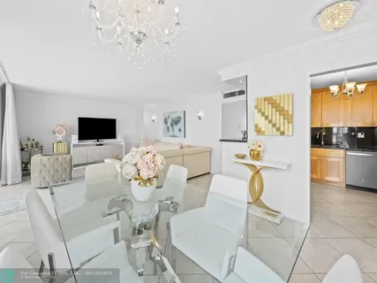 a living room with furniture a flat screen tv and kitchen view