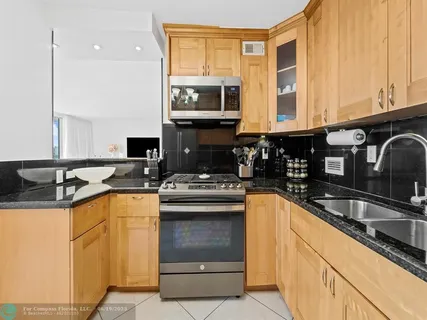 a kitchen with granite countertop a sink stainless steel appliances and cabinets
