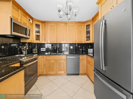 a kitchen with stainless steel appliances granite countertop a refrigerator and a stove top oven