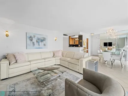 a living room with furniture and view of kitchen