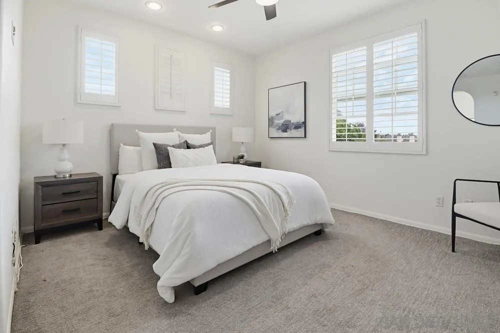 1293 Fools Gold Way, Unit 3 Chula Vista, CA 91913 - Photo 11 of 28 a bedroom with a bed a chandelier and a window