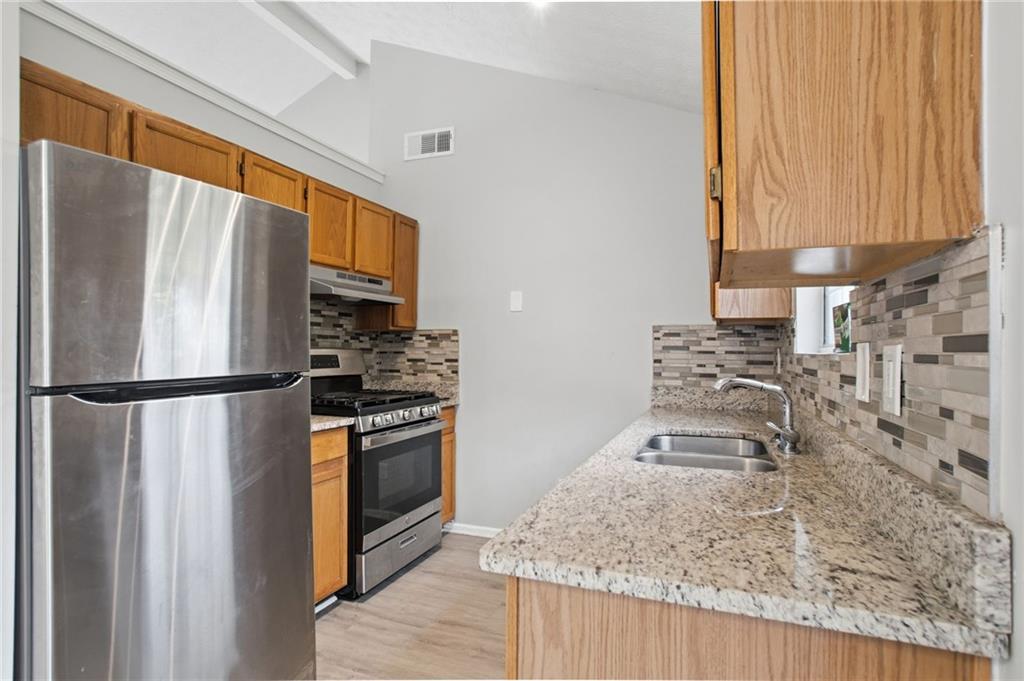 5855 Crescent Ridge Court Lithonia, GA 30058 - Photo 17 of 46 a kitchen with granite countertop a refrigerator and a sink