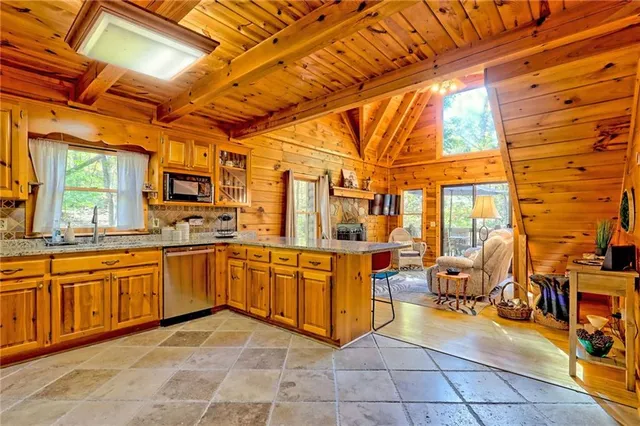 a large white kitchen with stainless steel appliances granite countertop a sink and cabinets