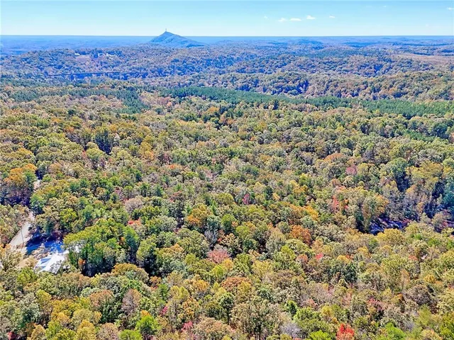 a dining room with stainless steel appliances kitchen island granite countertop a table chairs and a large window