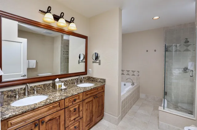 a spacious bathroom with a granite countertop sink mirror and shower
