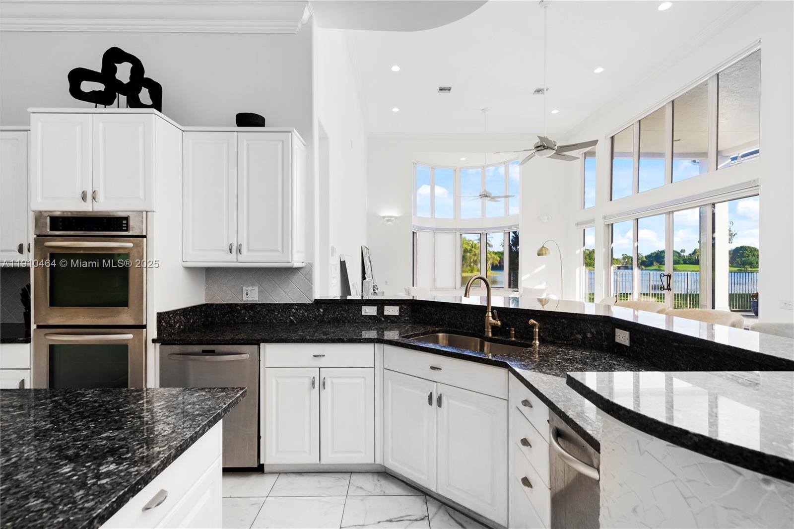 2939 Paddock Lane Weston, FL 33331 - Photo 16 of 59 a kitchen with granite countertop white cabinets and black appliances