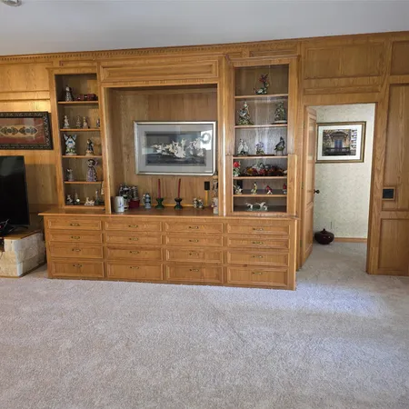 a view of an empty room with cabinet and flat screen tv
