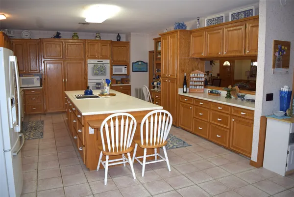 a kitchen with stainless steel appliances kitchen island granite countertop a refrigerator and a stove