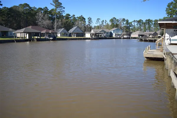 a front view of a house with yard and lake view