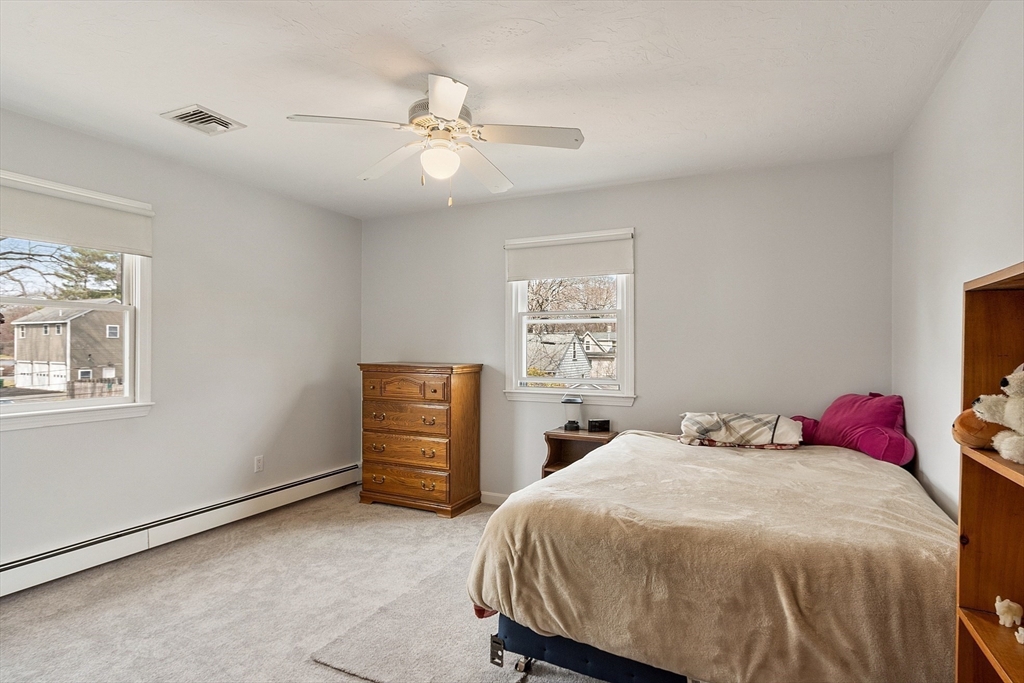 24 Washington Avenue Ashland, MA 01721 - Photo 20 of 30 a bedroom with a bed and a chandelier