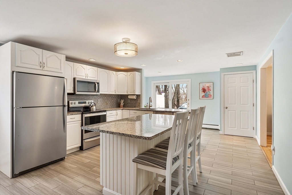24 Washington Avenue Ashland, MA 01721 - Photo 3 of 30 a kitchen with stainless steel appliances granite countertop a refrigerator and a stove top oven
